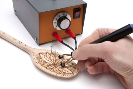 Peter CHild Pyrography machine burning onto a wooden spoon